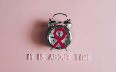 Alarm clock featuring an AIDS awareness ribbon on a pink background, symbolizing urgency and awareness.